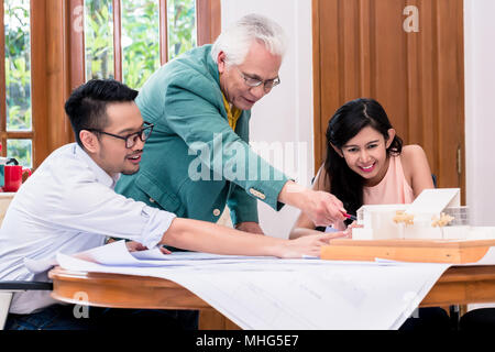 Successful senior architect congratulated by his colleagues Stock Photo