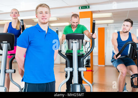 Physiotherapist and his encounter group during spinning in gym Stock Photo