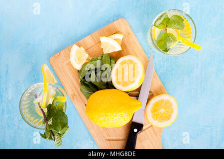 Top view of fresh cut lemons next to two glasses with lemonade Stock Photo