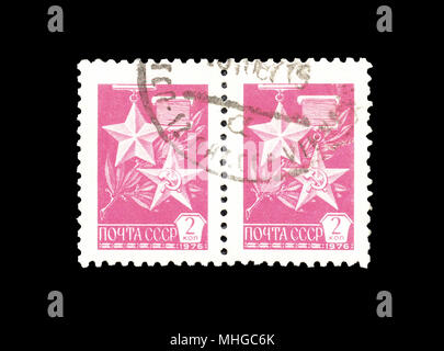 Cancelled postage stamps printed by Soviet Union,that shows Gold Star and Hammer and Sickle medals, circa 1976. Stock Photo