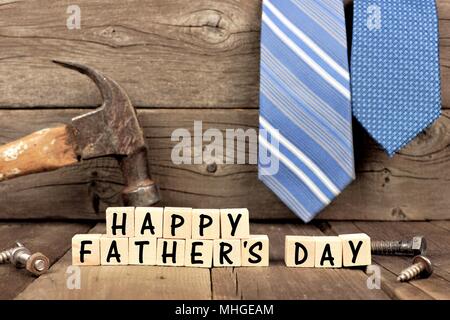 Happy Fathers Day wooden blocks with tools and ties in the background against rustic wood Stock Photo