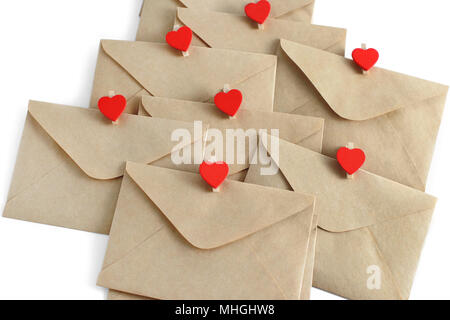 Envelopes from craft paper with red heart pins isolated on white background. Stock Photo