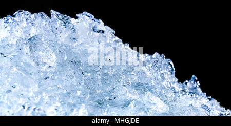 Pile of crushed ice cubes on dark background with copy space. Crushed ice cubes foreground for beverages. Stock Photo