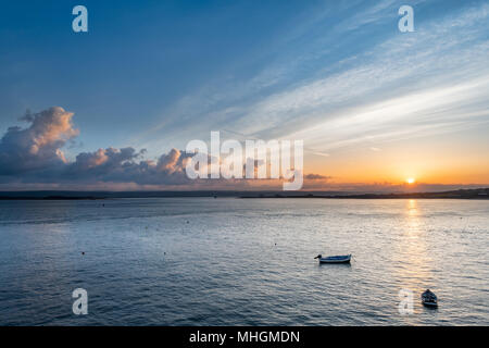 Instow, UK. 1st May 2018. UK Weather - The sun peeps over the horizon and cast a ray of sunlight across the River Torridge at Instow on the North Devon coast on the first day of May. Credit: Terry Mathews/Alamy Live News