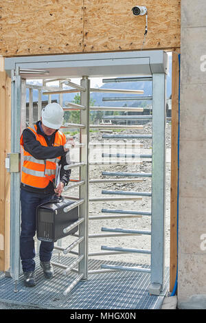 Cazis, Switzerland, 1st May 2018. An employee of the building authority enters the site through the security gate at the media event on the topping out of the new penal institution Realta in Cazis. Credit: Rolf Simeon/Alamy Live News Stock Photo