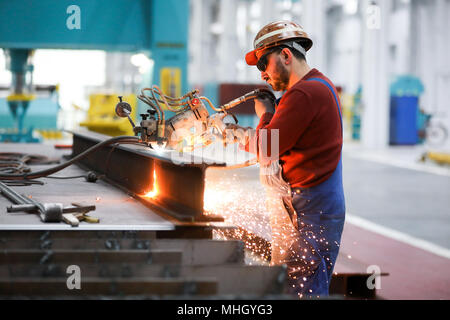 26 April 2018, Germany, Hamburg: Ramazan Solmaz, welder and machine operator, working with the autogenous plasma cutting device 'Kadett' in the modernised and renovated shipbuilding hall 2 in the shipyard facilities of Blohm Voss. Hamburg's traditional shipyard is set on a new course nearly a year and a half after the acquisition of Blohm Voss by Bremen's Luerssen Group. Photo: Christian Charisius/dpa Stock Photo