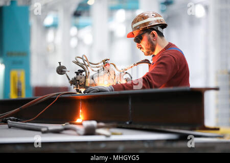 26 April 2018, Germany, Hamburg: Ramazan Solmaz, welder and machine operator, working with the autogenous plasma cutting device 'Kadett' in the modernised and renovated shipbuilding hall 2 in the shipyard facilities of Blohm Voss. Hamburg's traditional shipyard is set on a new course nearly a year and a half after the acquisition of Blohm Voss by Bremen's Luerssen Group. Photo: Christian Charisius/dpa Stock Photo