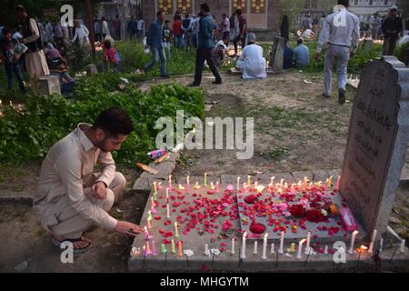May 1, 2018 - Srinagar, Jammu & Kashmir, India - A Kashmiri Shia Muslim light candles on graves on the occasion of Shab-e-Baraat.Every year, Shab-e-Barat is observed on the night between 14th and 15th of Sha'aban, which is the eighth month of the Islamic calendar. According to Islam, Shab-e-Barat means the night of forgiveness. It is considered to be the night when Allah forgives sinners.Shab-e-Barat is also known as Bara'a Night and Mid-Sha'ban. In The Arab world, it's referred to as Laylat al-Bara'at. The festival falls in the run up to Ramadan and is considered the night when Allah forgiv
