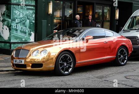 Brighton, United Kingdom - March 27 2018:   The Tequila sunrise painted Bentley Continental GT belonging to Dave Day, parked outside Browns Brasserie  Stock Photo