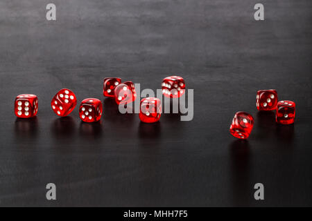 Dice in a chaotic manner are scattered on a dark background Stock Photo