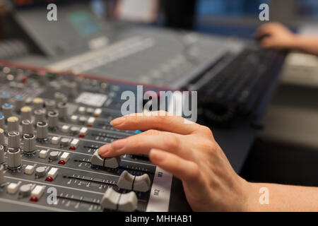 Female Radio Host Using Music Mixer In Studio Stock Photo