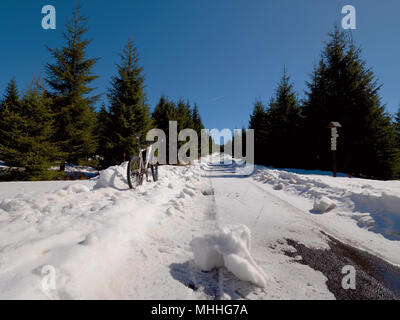 Cycling on large tyres in fresh snow. Biker goes by bike on the snowy road in the mountains. Picture taken in HDR mode. Stock Photo