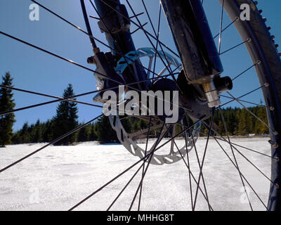 Cycling on large tyres in fresh snow. Biker goes by bike on the snowy road in the mountains. Picture taken in HDR mode. Stock Photo