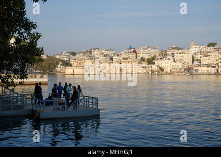 Group of young people on thebanks of Lake Pichola. Udaipur, also known as the City of Lakes, The Venice of the East, is the historic capital of the kingdom of Mewar, Rajasthan. Stock Photo