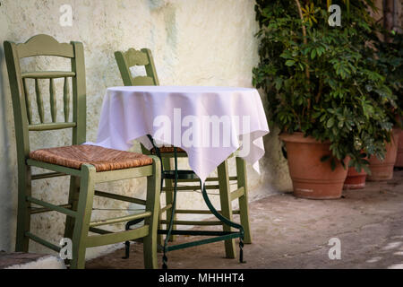 Green table and chairs outside on a sunny day in Athens Stock Photo