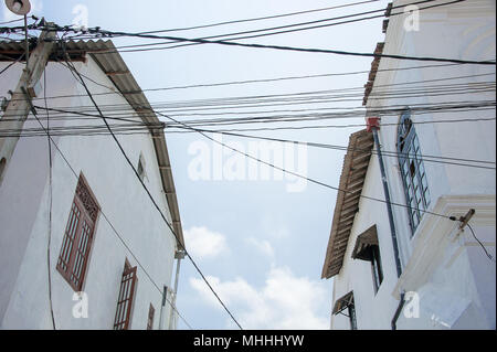 Street scene, Galle Fort, Sri Lanka. Multiple electricity cables connect buildings. Vintage facades under a soft blue sky Stock Photo