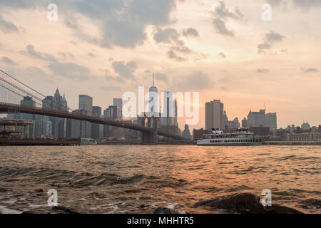 NEW YORK - USA - JUNE,12 2015ferry passing under manhattan bridge at sunset Stock Photo
