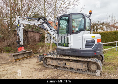 Small excavator parked on a construction site Stock Photo