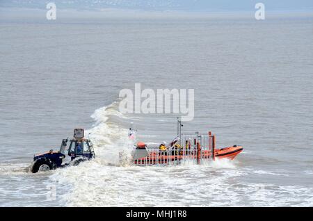 Launching Porthcawl lifeboat called out to an emergency on Porthcawl beach by ttractor Wales Cymru K GB Stock Photo