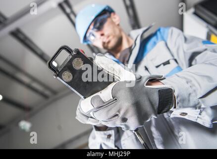 Heavy Duty Industrial Machinery Operator Worker with Cable Remote. Stock Photo