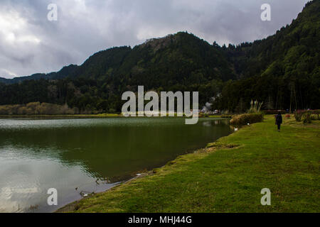 Stunning Landscape of Lake with green mountains surrounding and geothermal activity on volcanic island. Furnas Lagoon in Azores