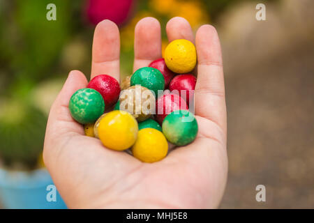 hand holding painted colorful rounded stones Stock Photo