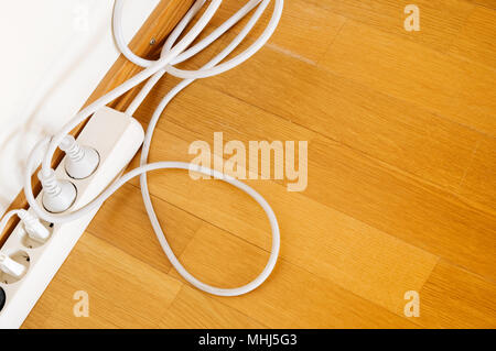 Multiple socket outlet on wooden floor. Stock Photo