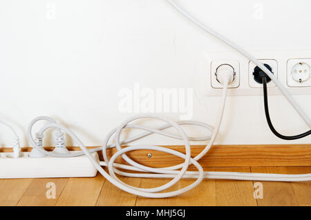 Gang socket and plugs connected to the outlet in a wall. Stock Photo