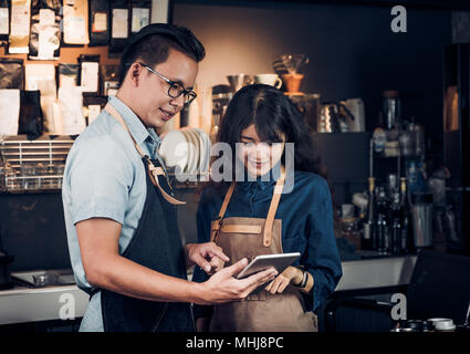 Asia Barista waiter take order from customer in coffee shop,cafe owner writing drink order at counter bar,Food and drink business concept,Service mind Stock Photo
