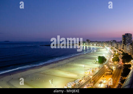 Night view of Copacabana beach during sunset in early evening, taken from the rooftop of a hotel, sky is purple. Rio de Janeiro, Brazil. Stock Photo
