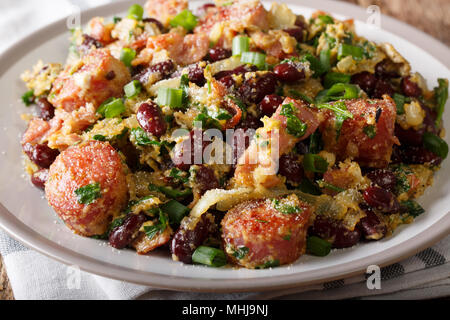 Brazilian fried Feijao Tropeiro with beans, sausage and bacon close-up on a plate on a table. horizontal Stock Photo