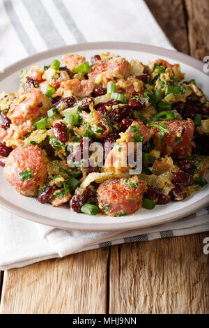 Brazilian food: Feijao Tropeiro with beans, sausage and bacon close-up on a plate on the table. vertical Stock Photo