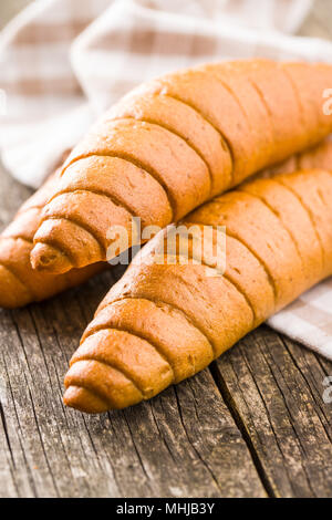 Salty bread rolls. Wholemeal croissants on old wooden table. Stock Photo