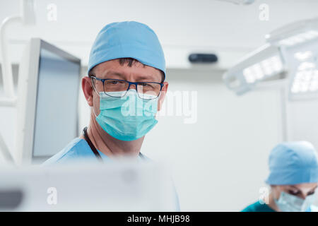 Anesthetist watching patient sleeping in operation room Stock Photo