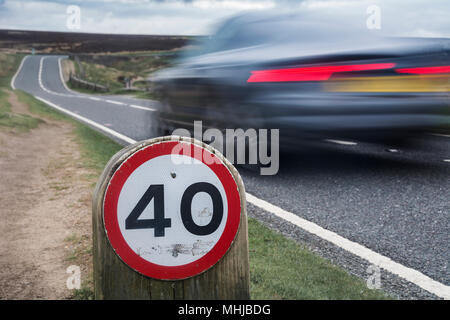 Speed limit sign on rural road with car Stock Photo