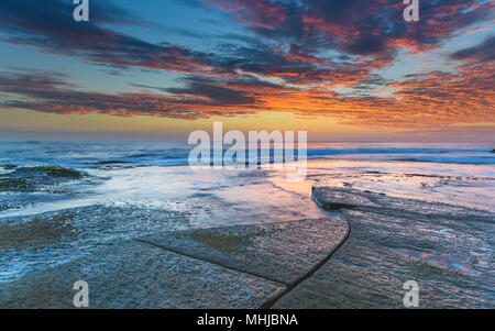 Seascape with Clouds from Rock Platform - Capturing the sunrise from The Skillion at Terrigal on the Central Coast, NSW, Australia. Stock Photo