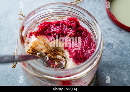 Forest Fruits Cheesecake in Jar with Spoon. / Unfinished Dessert. Organic Food. Stock Photo