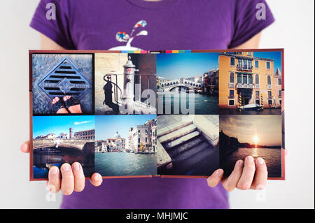 Opened square travel photo album in woman hands background Stock Photo