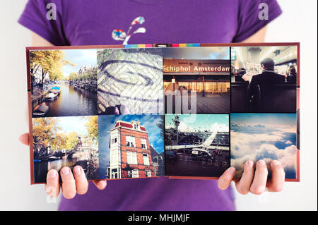 Opened square travel photo album in woman hands background Stock Photo