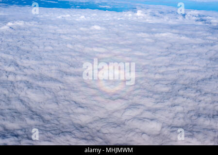 A small circular rainbow, known as a 'glory,' from an airplane. Stock Photo