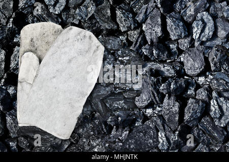 Work gloves on coal background. Place for text. Copy space. High quality coal mined in Kuznetzk basin. Coal-basin.Kuzbass. Western Siberia Stock Photo