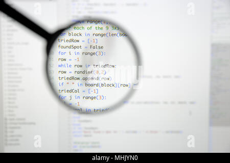 Real Python code developing screen. Programing workflow abstract algorithm concept. Lines of Python code visible under magnifying lens. Stock Photo