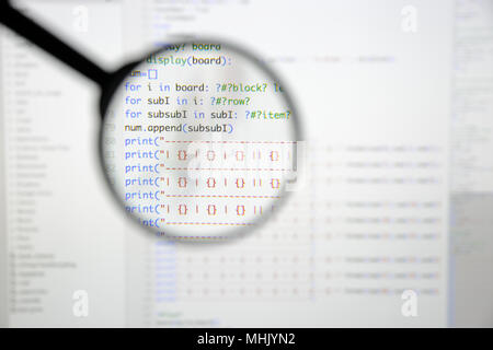 Real Python code developing screen. Programing workflow abstract algorithm concept. Lines of Python code visible under magnifying lens. Stock Photo
