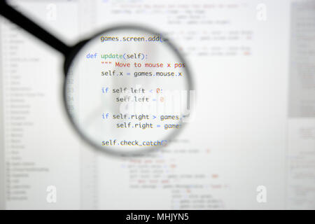 Real Python code developing screen. Programing workflow abstract algorithm concept. Lines of Python code visible under magnifying lens. Stock Photo