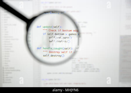 Real Python code developing screen. Programing workflow abstract algorithm concept. Lines of Python code visible under magnifying lens. Stock Photo