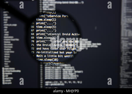 Real Python code developing screen. Programing workflow abstract algorithm concept. Lines of Python code visible under magnifying lens. Stock Photo