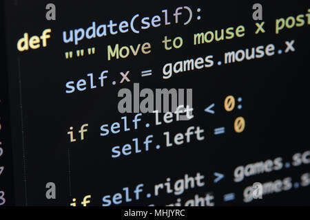Real Python code developing screen. Programing workflow abstract algorithm concept. Lines of Python code visible under magnifying lens. Stock Photo