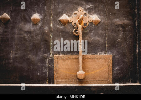Brass door knocker on a dark wooden door. Landscape format. Stock Photo