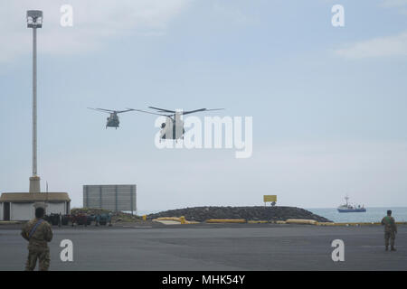 A pair of Hawaii Army National Guard CH-47 Helicopters assigned to the Company B, 1st Battalion, 171st Aviation Regiment approach Honolulu Harbors Pier #1.  The Helicopters are to be partially disassembled in preparation to be shipped to the continental United States. Soldiers from the Company B, 777th Aviation Support Battalion assisted in the breakdown.  March 16, 2018, Honolulu Harbor (U.S. National Guard Stock Photo