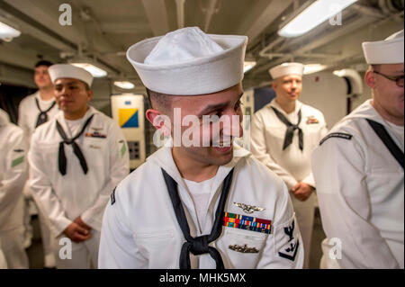 NORFOLK, Va. (March 20, 2018) Aviation Ordnanceman 3rd Class Julio Pino laughs after a service dress white uniform inspection aboard the aircraft carrier USS George H.W. Bush (CVN 77). The ship is in port in Norfolk, Virginia, conducting sustainment exercises to maintain carrier readiness. (U.S. Navy Stock Photo